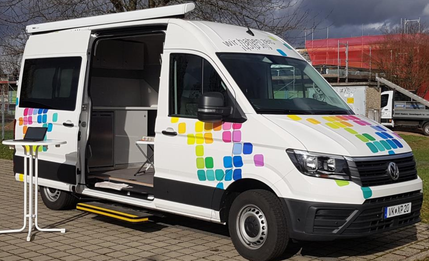 ein weißer Bus mit bunten Puzzleteilen