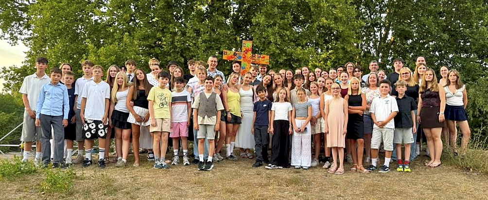 Gruppe der Messdiener mit ihren Betreuern, in der Mitte das selbstgestaltete Kreuz