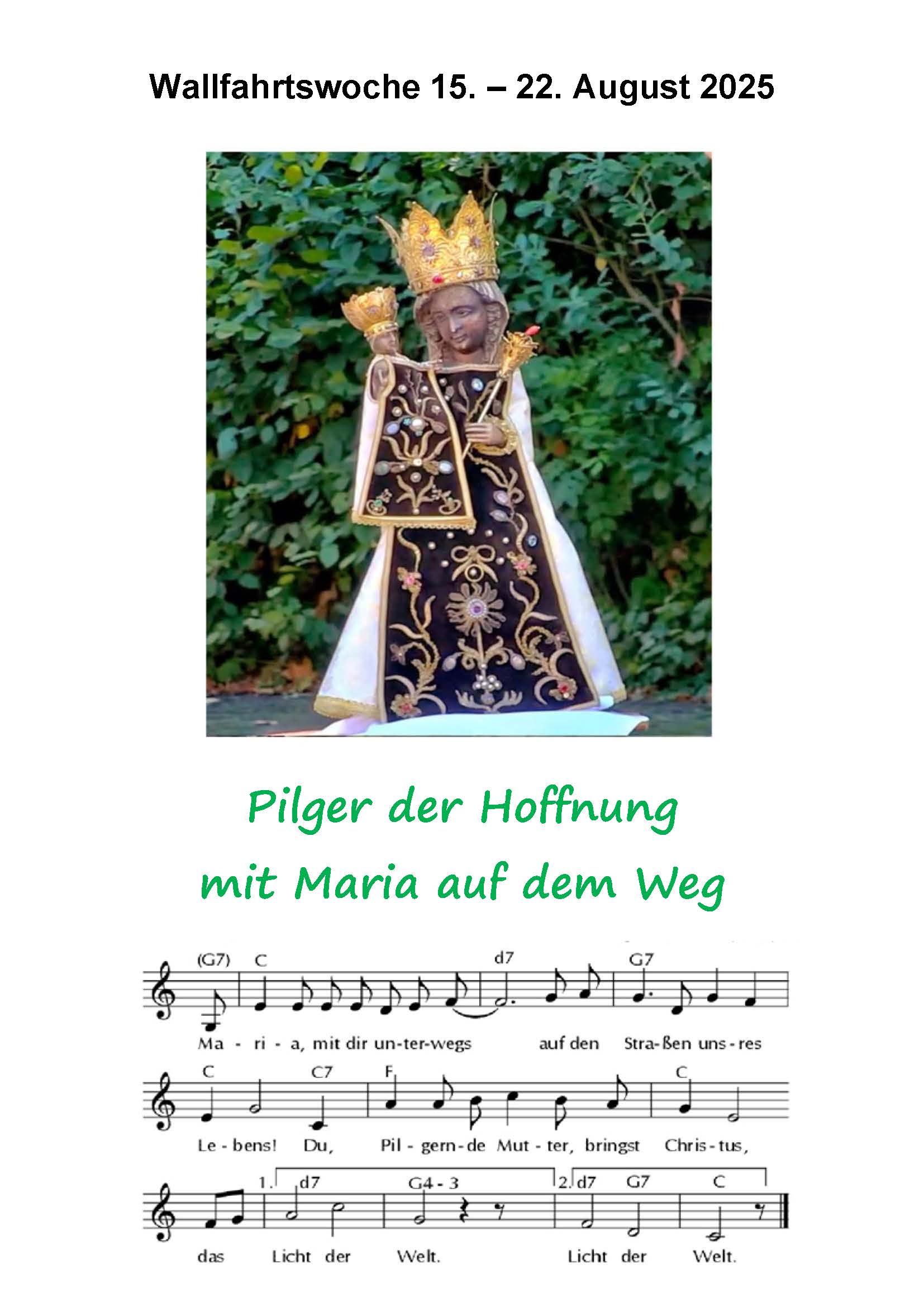 schwarze Madonna vor einer grünen Hecke
