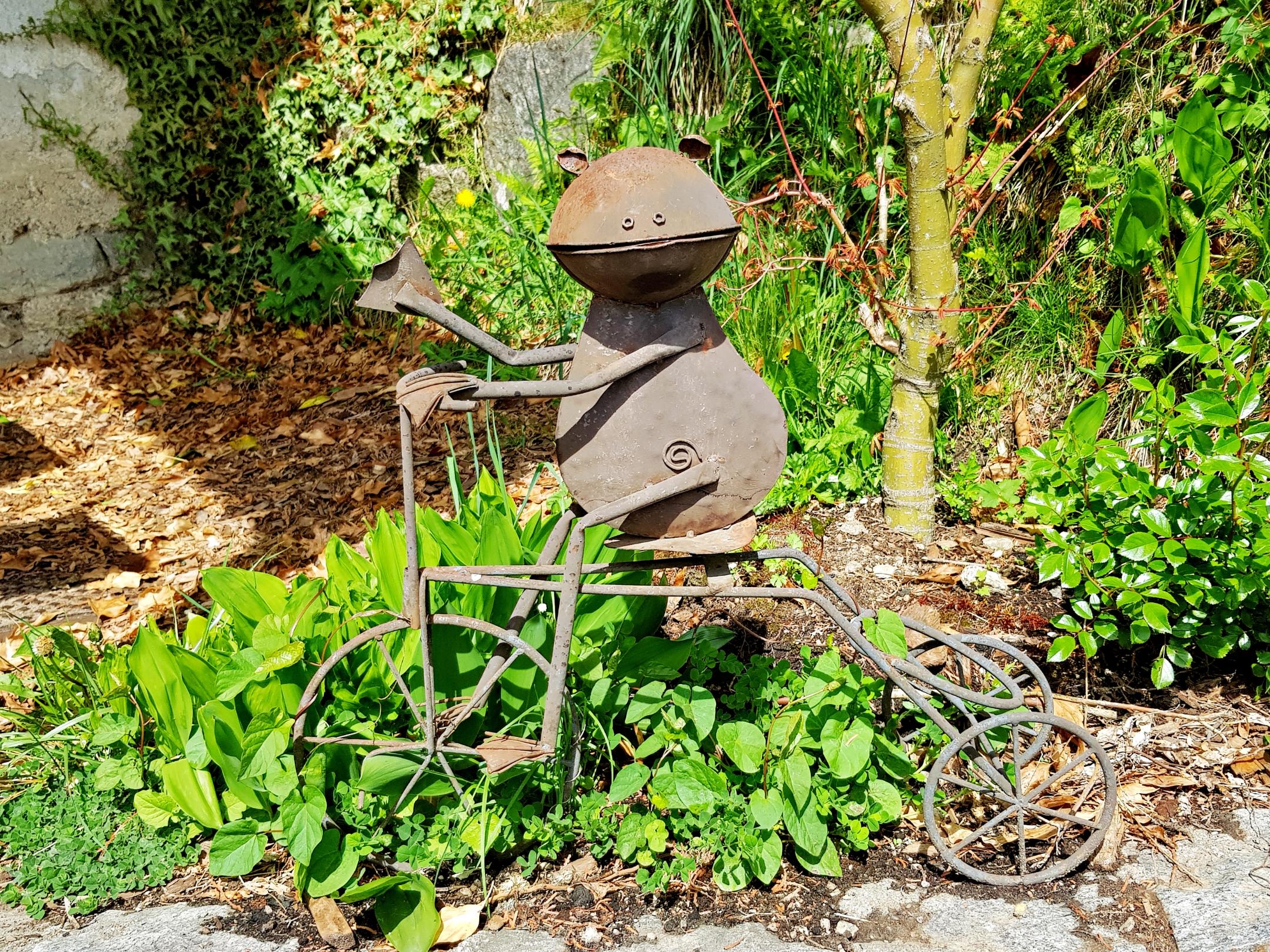 Frosch auf einem Fahrrad. Die Skulptur ist aus verrostetem Stahl